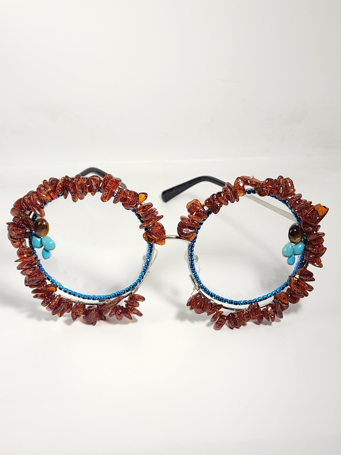 Round eyeglass with blue frame embellished with brown stones