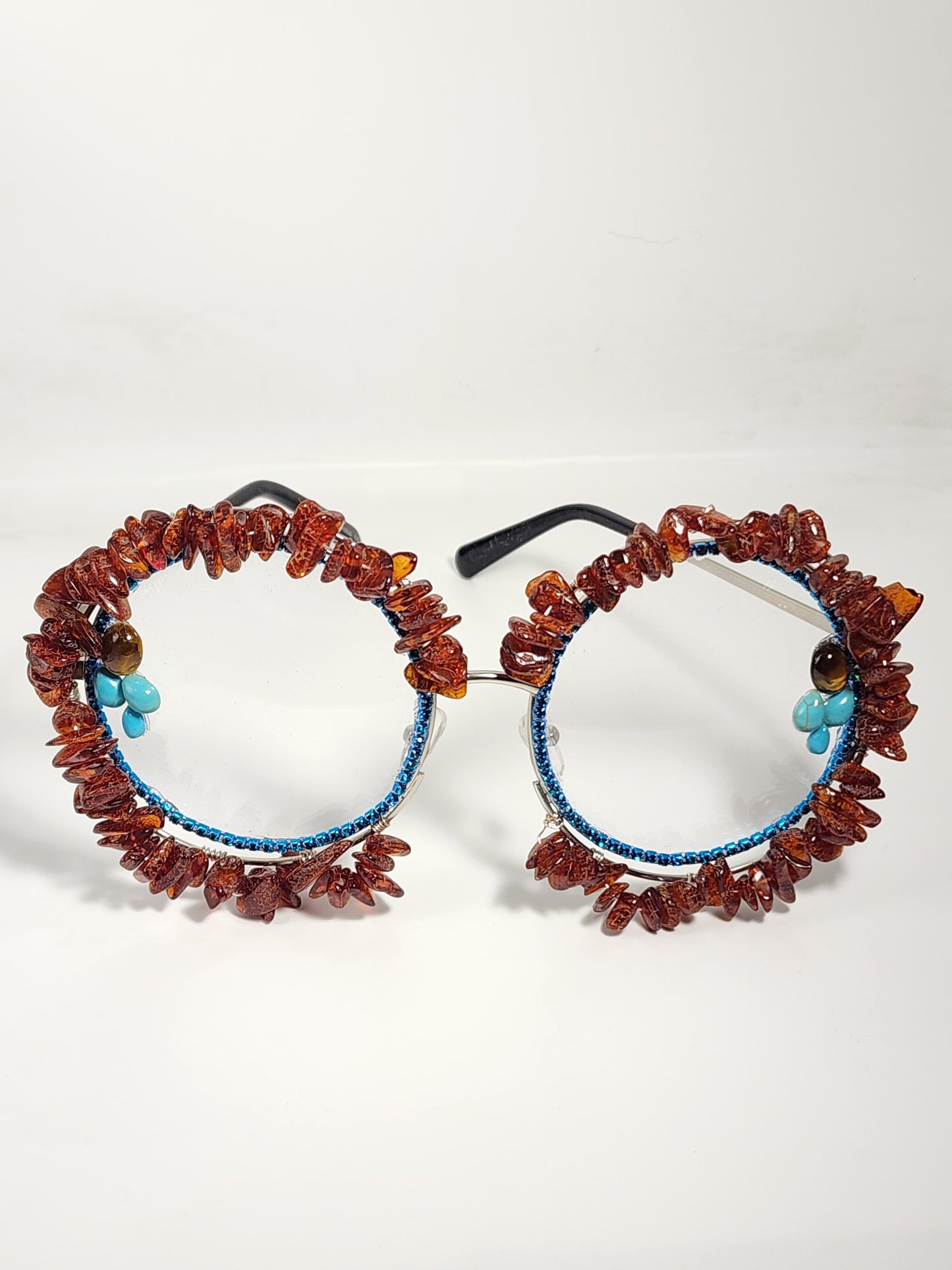 Round eyeglass with blue frame embellished with brown stones